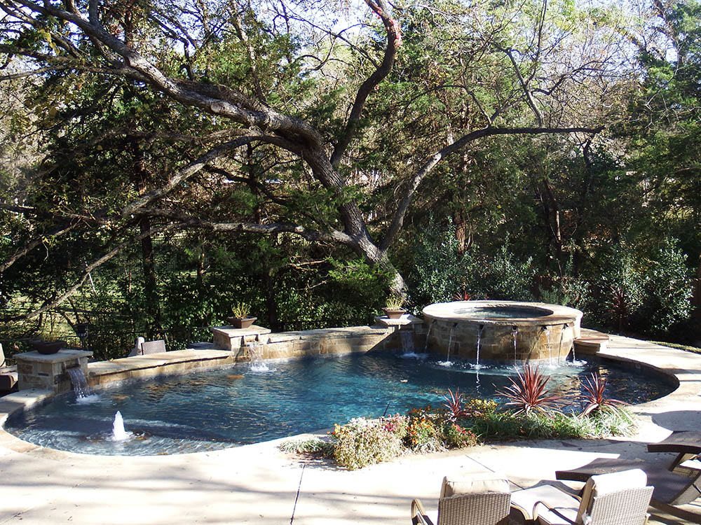 Freeform pool with sheer-descent water features and elevated spa